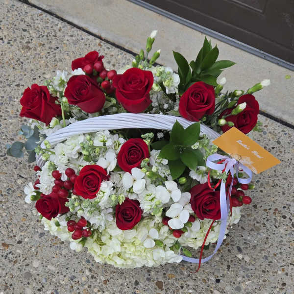 Basket arrangement of red roses and white flowers with ribbon