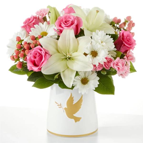 Pink roses and white lilies in a white vase with a gold dove design