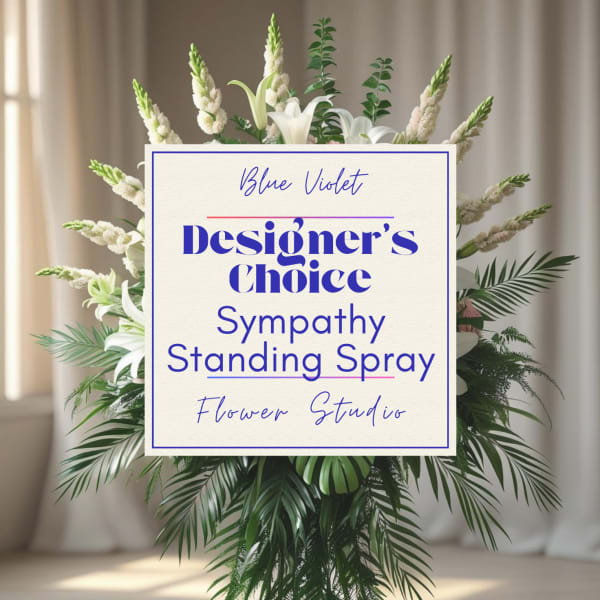 Standing sympathy spray with white lilies and greenery behind a sign