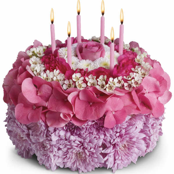 Pink floral cake with lit candles on top