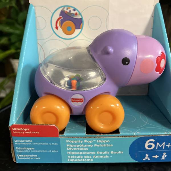 Packaged Fisher-Price hippo toy with orange wheels