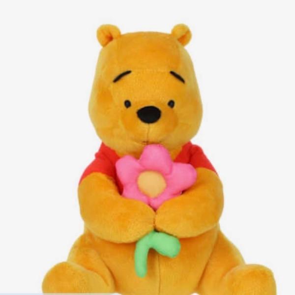 Plush Winnie the Pooh holding a pink flower