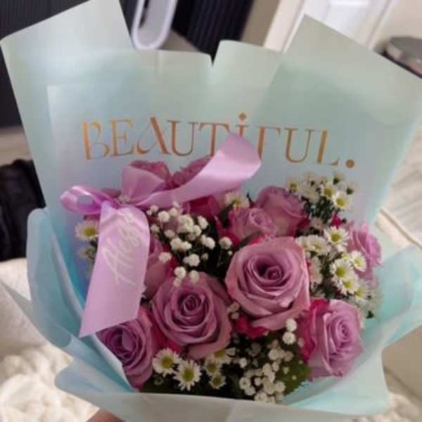 Bouquet of pink and lavender roses with small white filler flowers