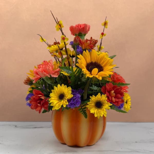 Colorful mixed flower arrangement in an orange pumpkin-shaped vase