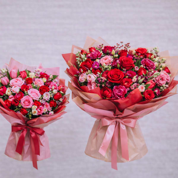 Three bouquets of red and pink roses wrapped in pink paper