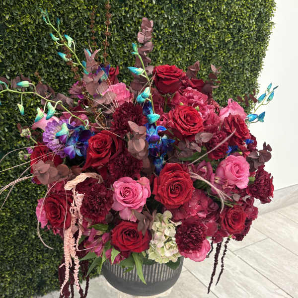 Large bouquet of red and pink roses in a dark vase