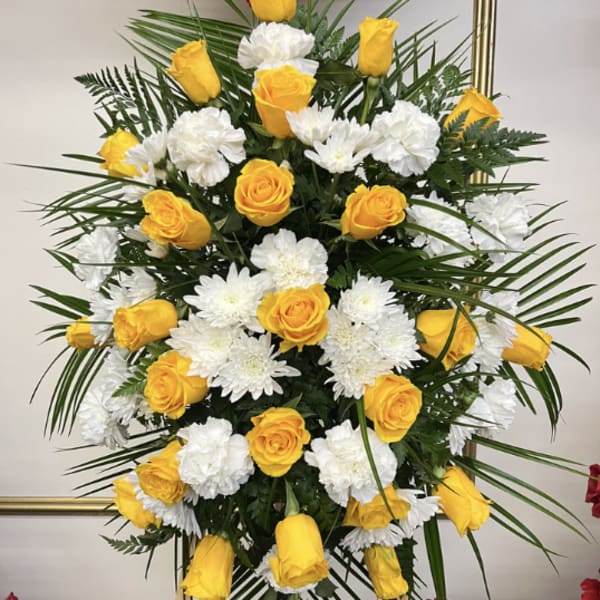 Yellow roses and white chrysanthemums in a tall standing arrangement