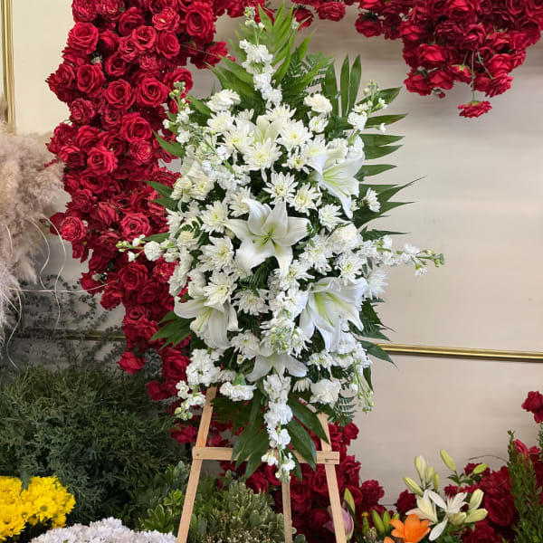 White lily and chrysanthemum arrangement on a wooden easel