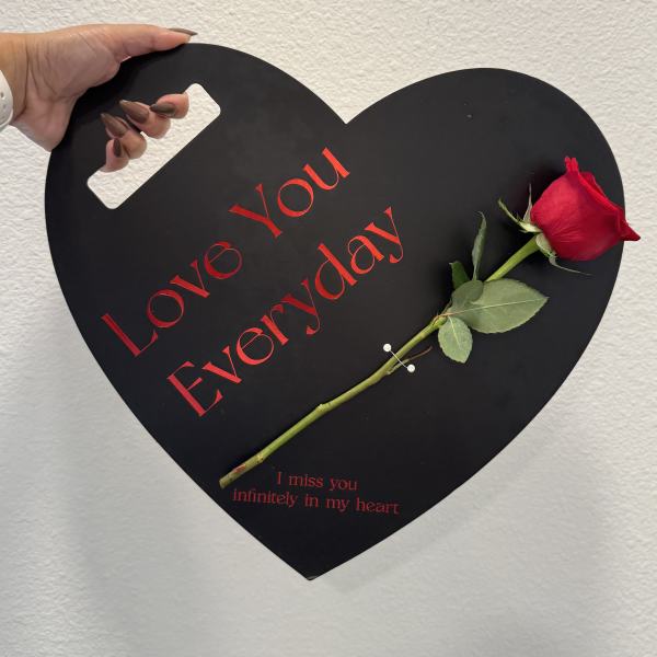 Black heart-shaped sign with a red rose and memorial text
