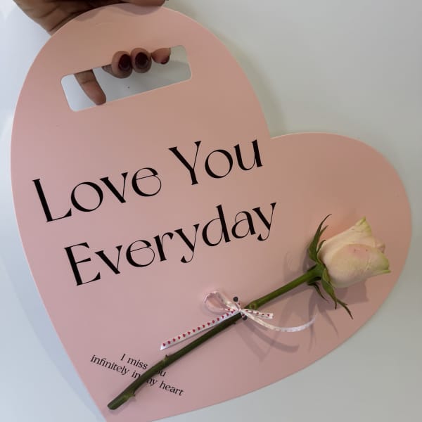 Pink heart-shaped sign with a white rose and the words Love You Everyday