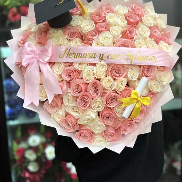 Heart-shaped bouquet of pink and white roses with a graduation cap topper