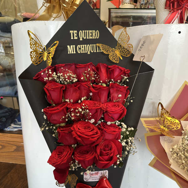 Red roses in a black cone wrap with a red ribbon and gold butterfly accents