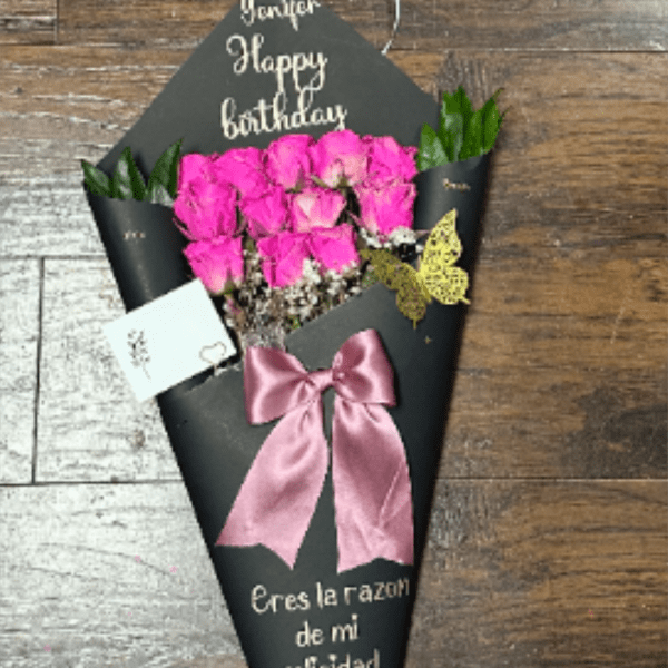 Pink rose bouquet in black wrap with a satin bow and birthday message