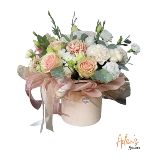 Pastel bouquet in a round hatbox with pink roses and white blooms