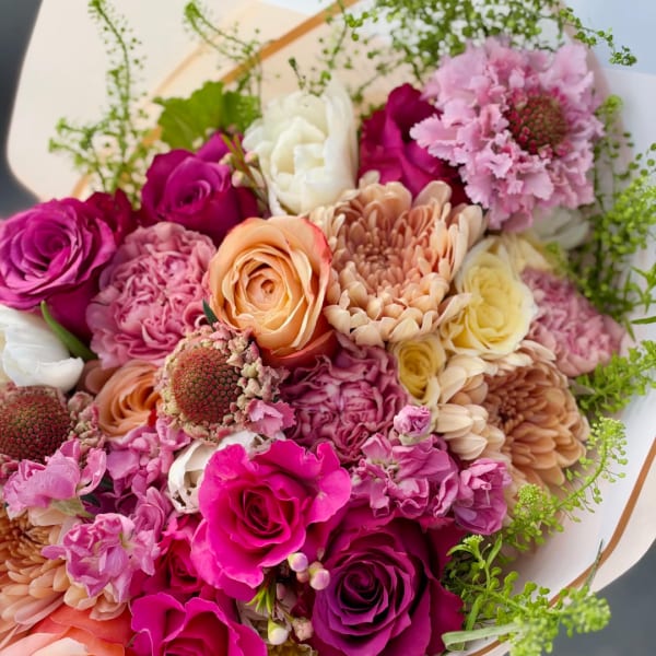 Bouquet of pink, peach, and white flowers with green filler