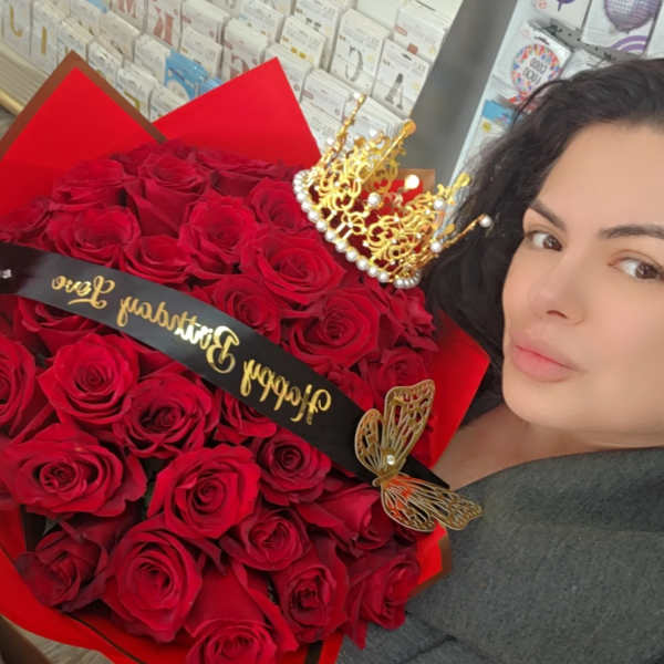 Large bouquet of red roses with a gold crown and black ribbon