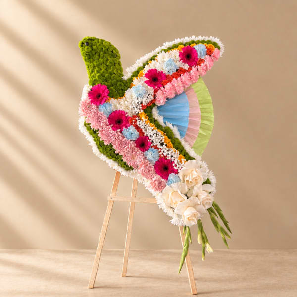 Colorful floral arrangement shaped like a butterfly on a wooden easel