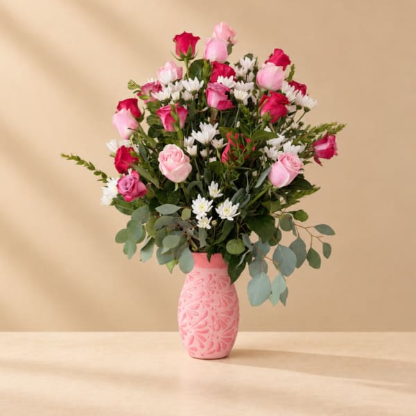 Pink and red roses with white daisies in a pink vase