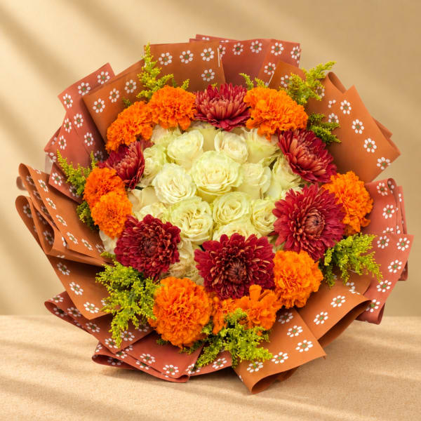Bouquet of cream roses, orange marigolds, and burgundy mums in patterned wrap
