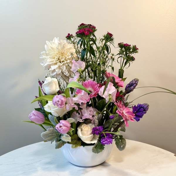 Mixed bouquet in a white bowl vase with pink, white, and purple flowers