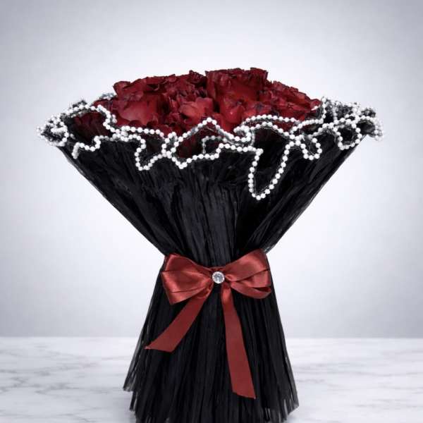 Bouquet of red roses wrapped in black paper with a red ribbon