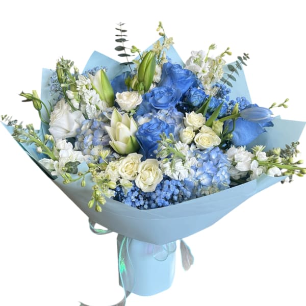 Blue and white bouquet with roses, lilies, and hydrangeas wrapped in pale blue paper