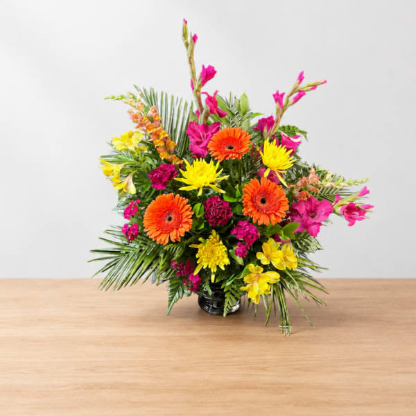 Bright mixed flower arrangement in a black vase