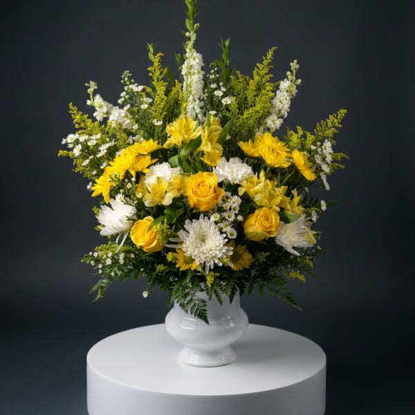 Yellow and white floral arrangement in a white vase