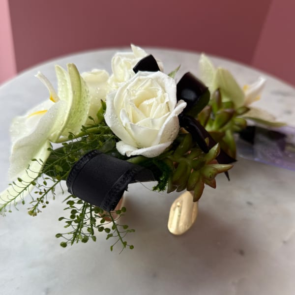 White rose and calla lily boutonniere with black ribbon and greenery