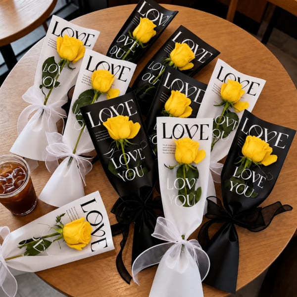Yellow roses wrapped in black and white paper with "LOVE YOU" text