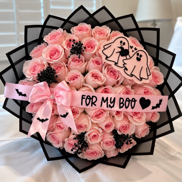 Pink rose bouquet with a ribbon and Halloween-themed decorations