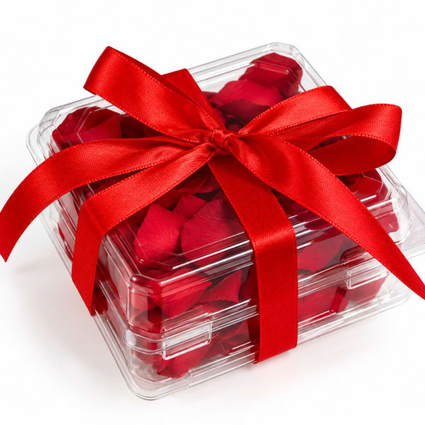 Clear gift box filled with red rose petals and tied with a red ribbon