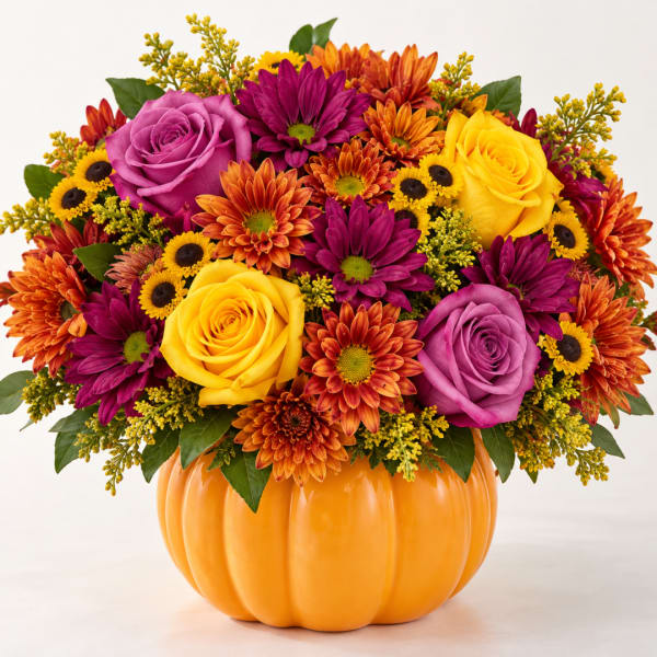 Mixed bouquet in a pumpkin-shaped orange container with roses and daisies