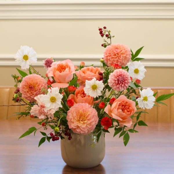 Peach and white floral arrangement in a ceramic vase