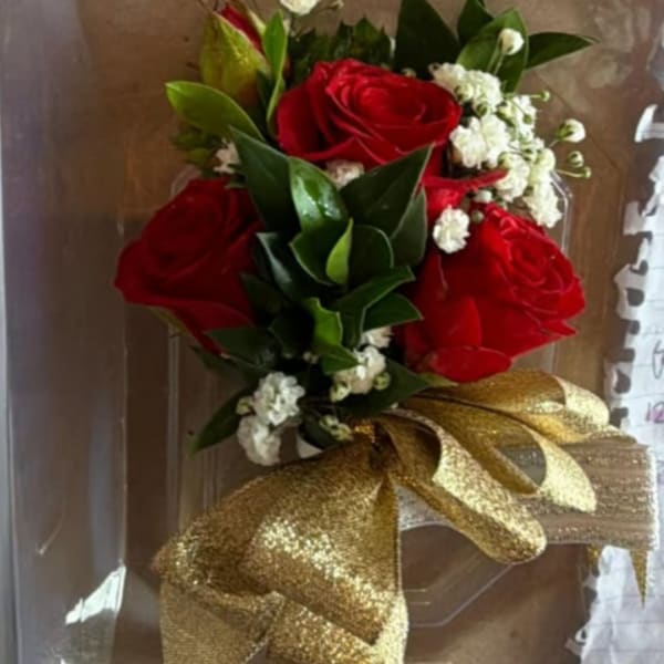 Red rose bouquet with white filler flowers and a gold ribbon