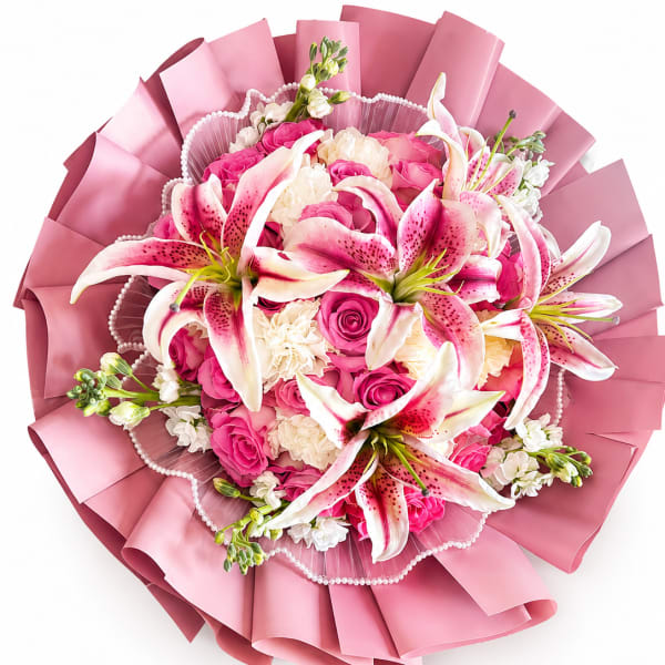 Pink and white bouquet with lilies and roses wrapped in pink paper