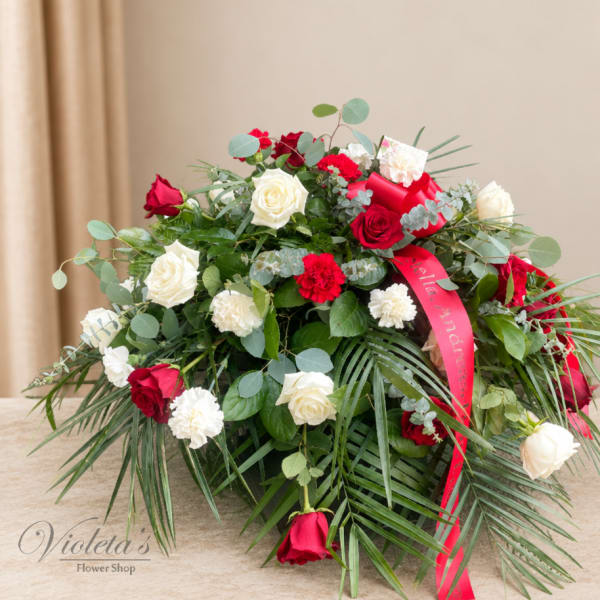 Red and white rose arrangement with carnations and a red ribbon