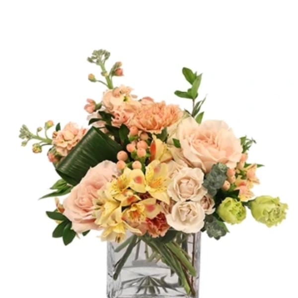 Peach and cream bouquet in a clear glass vase