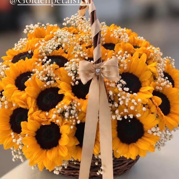 Basket of sunflowers with baby's breath and a ribbon bow