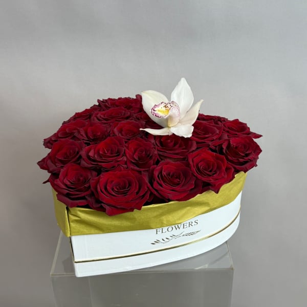 Red roses in a white hat box with a white orchid on top