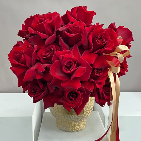Red rose bouquet in a gold textured vase with ribbon