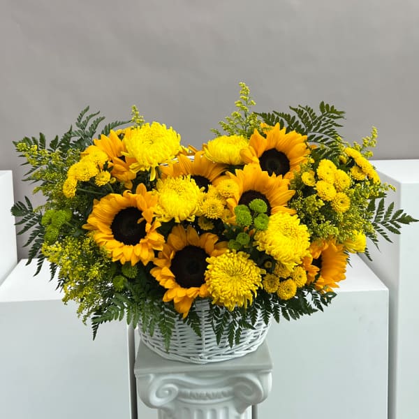 Yellow sunflowers and chrysanthemums in a white basket
