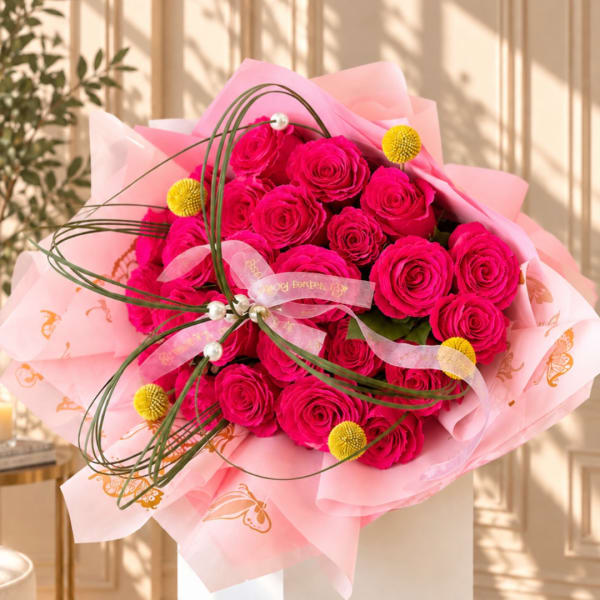 Hot pink rose bouquet wrapped in pale pink paper with ribbon accents
