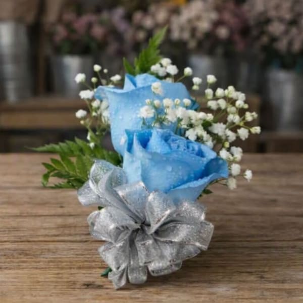 Blue and silver rose bouquet with baby's breath on a wooden table