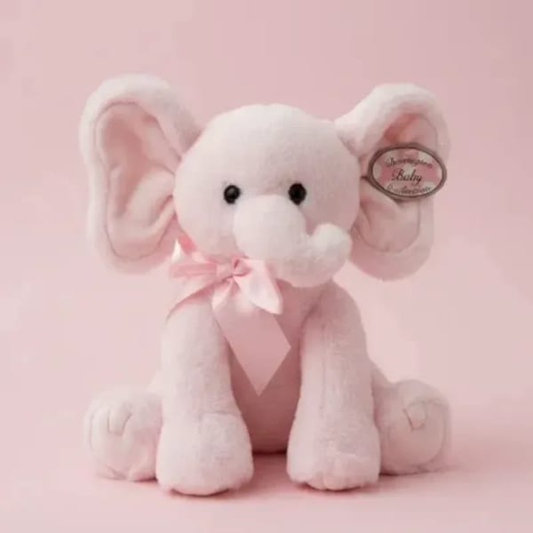 Pink plush elephant with a ribbon bow on a pink background