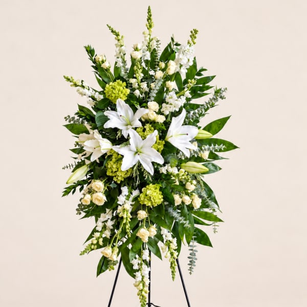 White lilies and cream roses in a tall standing floral spray