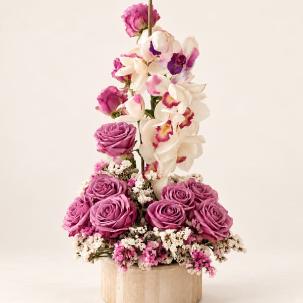 Pink roses and white orchids arranged in a wooden box