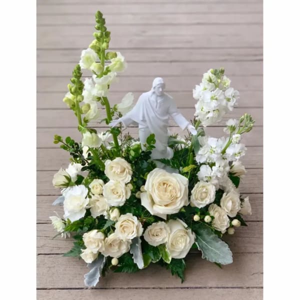 White rose arrangement with a small white figurine in the center