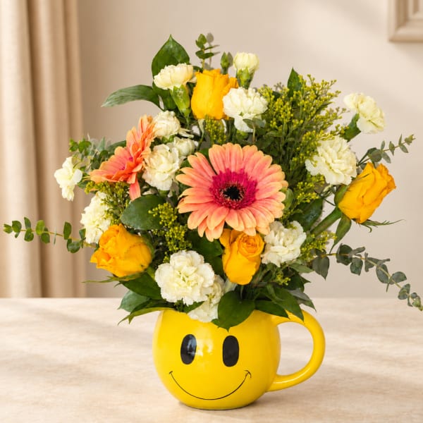 Mixed bouquet in a yellow smiley-face mug vase