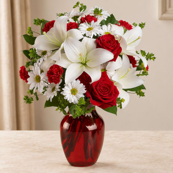 Red roses and white lilies in a red glass vase